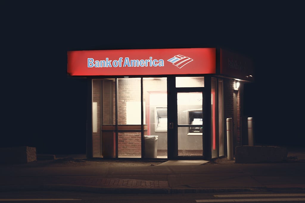 Illuminated Bank of America ATM structure against a dark nighttime backdrop in Boston.
